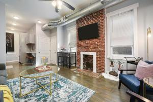 una sala de estar con una pared de ladrillo y una mesa en HostWise Stays - The James Apt 1 - Patio, Free Street Parking, en Pittsburgh