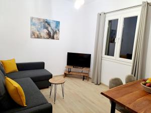a living room with a couch and a table at Πλατανακι 1 Family Friendly in Andros