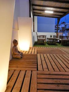 a teddy bear sitting on a wooden deck with a lamp at Romántico estudio centro de Algeciras in Algeciras