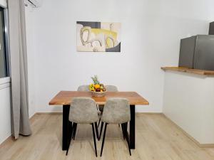アンドロスにあるΠλατανακι 2 Seaview Apartmentのダイニングルームテーブル(椅子2脚付)、フルーツ1杯