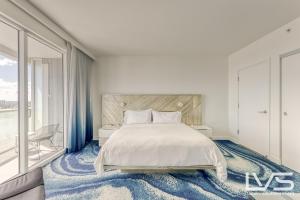 1 dormitorio con cama y ventana grande en W Hotel Ftl Beach Oceanview 2Bed 2Bath Condo Resort, en Fort Lauderdale