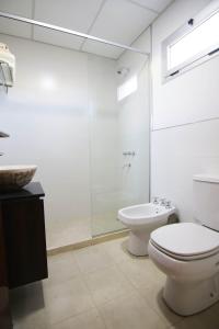 uma casa de banho com um WC, um chuveiro e um lavatório. em Hotel Terra Patagonia em Malargüe