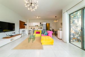 a living room with a yellow couch and colorful chairs at Beachcove Apt No 10 in Pereybere