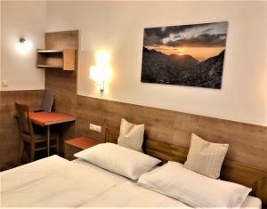 a hotel room with two beds and a desk at Pension Vocario in Pfarrwerfen