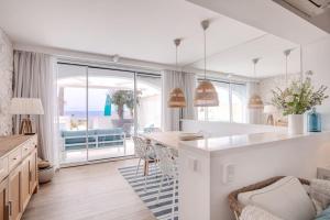 a white kitchen with a table and a view of the ocean at Beautiful 2 bedrooms town house. Frontline beach in Manilva