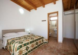 1 dormitorio con 1 cama grande y baño en Villaggio Club Degli Ulivi en Vieste