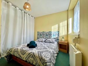 a bedroom with a bed with a blue hat on it at COC - Soleil Levant in Wissant