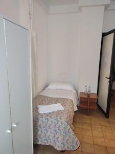 a small bedroom with a bed and a table at Hotel Italia in Reggio Emilia