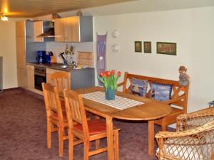 eine Küche mit einem hölzernen Esstisch und Stühlen in der Unterkunft Ferienwohnung mit großem Balkon in Bömitz in Bömitz