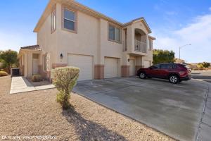 a red car parked in a parking lot in front of a house at Beautiful Condo at the Springs By Cool Properties in Mesquite