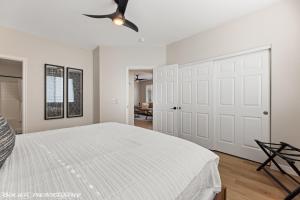 a white bedroom with a bed and a ceiling fan at Beautiful Condo at the Springs By Cool Properties in Mesquite