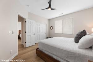 a white bedroom with a bed and a ceiling fan at Beautiful Condo at the Springs By Cool Properties in Mesquite