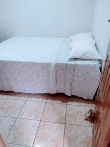 - un lit installé au-dessus d'un sol carrelé dans l'établissement Casa aconchegante ao lado da Igreja Matriz- Bananeiras-PB, à Bananeiras