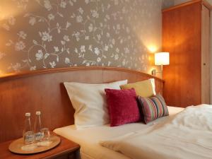a bedroom with a bed with red and white pillows at Hotel Stare Miasto Old Town in Poznań
