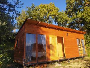 una piccola cabina in legno in un campo alberato di Agricampeggio la casa di Nicla a Cavriglia