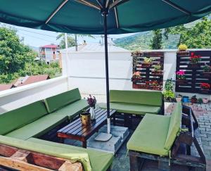 a patio with two green chairs and an umbrella at BÖ villa in Macka