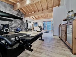 a fitness room with a gym with a bench and weights at Chalets Mariasteinerhof in Mariastein
