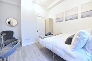 - une chambre avec un lit et une chaise dans l'établissement Central London Luxury Studios Fulham Close to Underground Newly Refurbished, à Londres