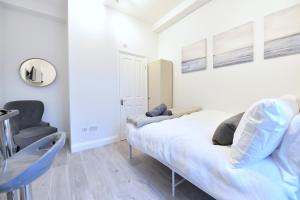ein Schlafzimmer mit einem Bett und einem Stuhl in der Unterkunft Central London Luxury Studios Fulham Close to Underground Newly Refurbished in London