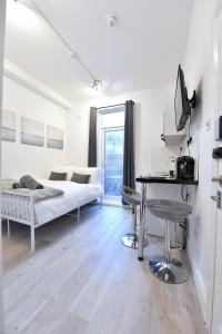 a bedroom with a bed and a desk with a computer at Central London Luxury Studios Fulham Close to Underground Newly Refurbished in London