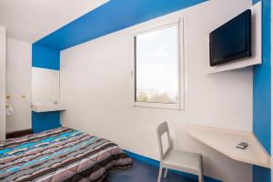 Habitación con cama, escritorio y TV. en hotelF1 Colmar Parc des Expositions, en Colmar