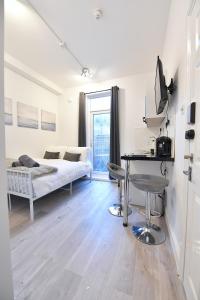 Schlafzimmer mit einem Bett, einem Tisch und einem Schreibtisch in der Unterkunft Central London Luxury Studios Fulham Close to Underground Newly Refurbished in London