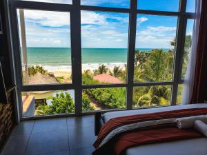 1 dormitorio con vistas al océano desde una ventana en Kasumai Beach Resort, en Bijilo