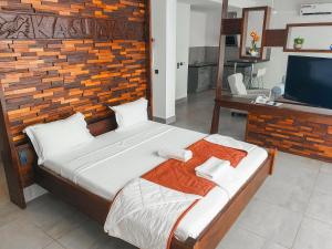 a bedroom with a large bed and a flat screen tv at Kasumai Beach Resort in Bijilo