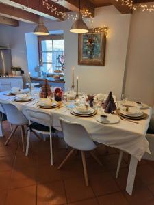 mesa de comedor con mantel blanco y velas en B&B Ai Castagni, en Tenno