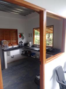 a kitchen with a counter and two windows at Cabaña Caporo - privada con ubicación central in Acanti
