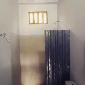a bathroom with a toilet and a window on the wall at Cabaña Caporo - privada con ubicación central in Acanti
