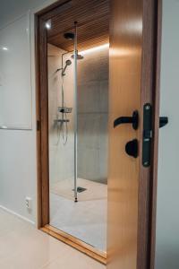 La salle de bains est pourvue d'une douche et d'une porte en verre. dans l'établissement Meriaitat, à Kokkola