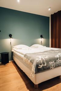 a bedroom with a white bed with a green wall at Meriaitat in Kokkola