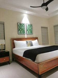 a bedroom with a large wooden bed with white pillows at J’s Pyramid Point Vacation Stay in Ocho Rios