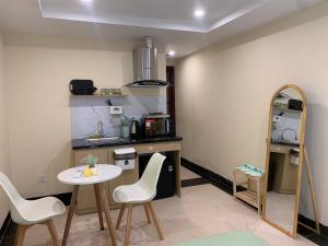 a kitchen with a table and chairs and a mirror at Mino Homestay in Hanoi