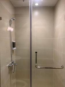 y baño con ducha y puerta de cristal. en Mino Homestay, en Hanói