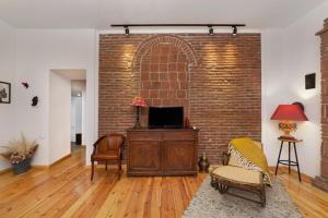a living room with a brick wall and a tv at Duplex Opera 3 in Tbilisi City