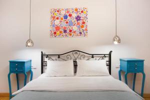 - une chambre avec 2 tables de chevet bleues à côté d'un lit dans l'établissement Duplex Opera 3, à Tbilissi