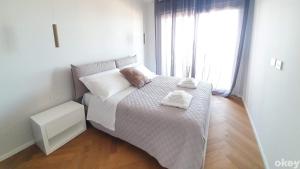 Cama pequeña en habitación con ventana grande en Seven Seas Luxury Apartments - Bari San Girolamo, en Bari