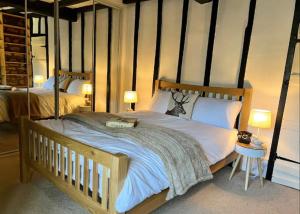 a bedroom with a large bed with a wooden frame at China Cottage - Quaint, Cosy, Cotswolds Retreat in Charlbury