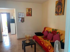ein Wohnzimmer mit einem Sofa und einem Tisch in der Unterkunft Appartement Hibiscus in Basse-Terre