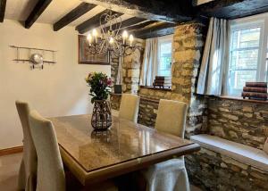 China Cottage - Quaint, Cosy, Cotswolds Retreat في تشارلبوري: غرفة طعام مع طاولة وكراسي خشبية