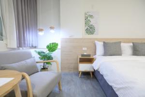 una camera da letto con due letti, un tavolo e una sedia di 161 Easy Inn a Yuchi