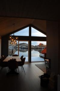 a dining room with a table and a large window at Visit Mortsund, Lofoten in Leknes