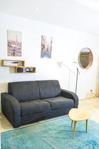 ein Wohnzimmer mit einem Sofa und einem Tisch in der Unterkunft Appartment Montorgueil/Châtelet in Paris