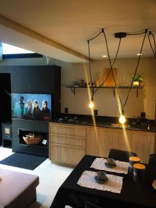 a living room with a kitchen with a tv and a table at Tiny House Cambará in Cambará