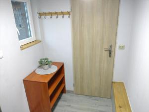 a bathroom with a wooden door and a wooden dresser at Agroturystyka u Marcelki in Hoczew