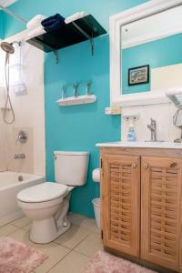 a bathroom with a toilet and a tub and a sink at Hellshire Portmore Vacation Home in Portmore