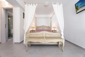 a bedroom with a canopy bed with two lamps at Beachside Bungalows in Athens