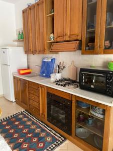 eine Küche mit Holzschränken und einem Herd mit Backofen in der Unterkunft Belmare trilocale a piano terra indipendente in San Vito lo Capo